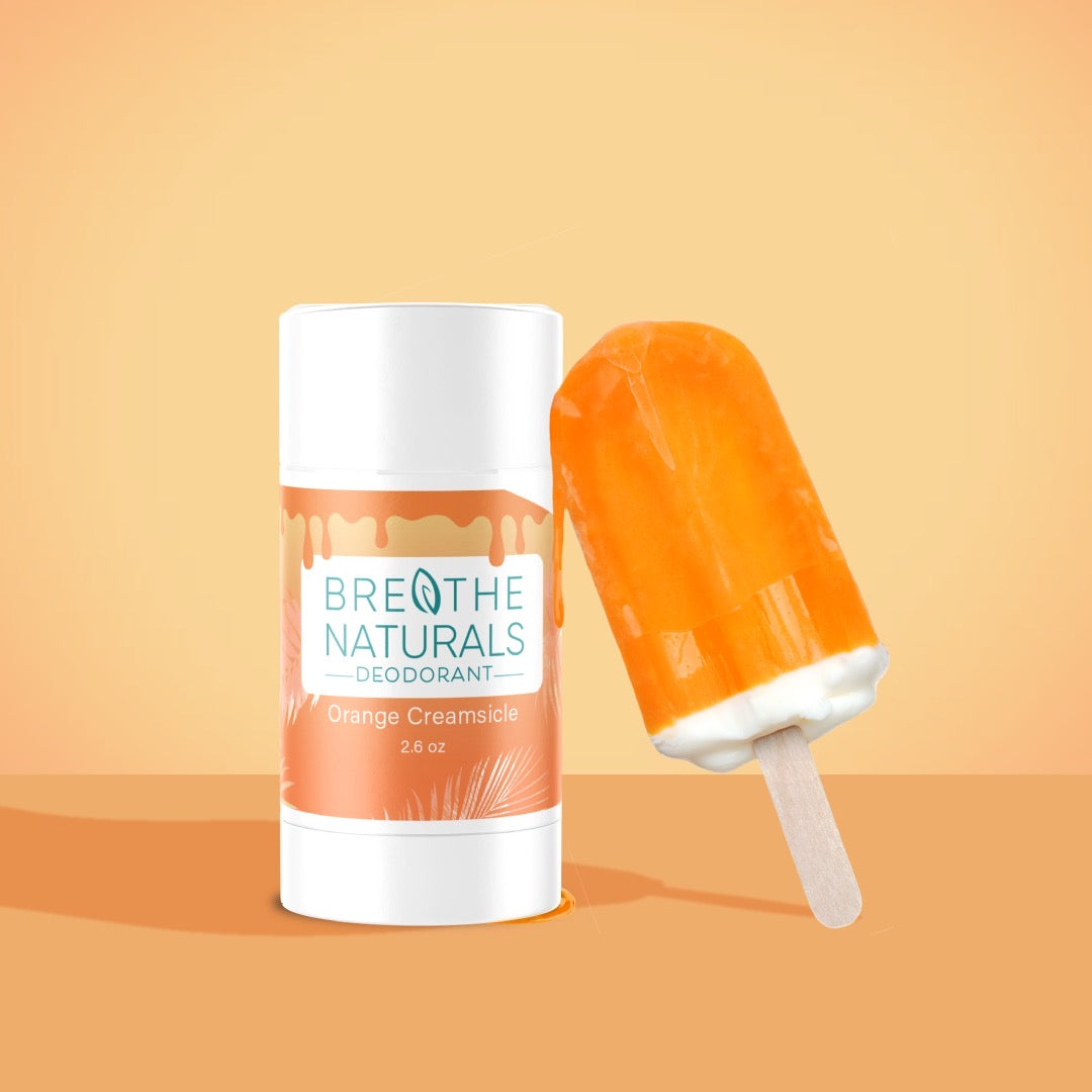 Breathe Naturals orange creamsicle deodorant poses next to a matching orange creamsicle popsicle.
