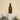 Brown spray bottle labeled 'daybreak' on a beige background with floral elements.