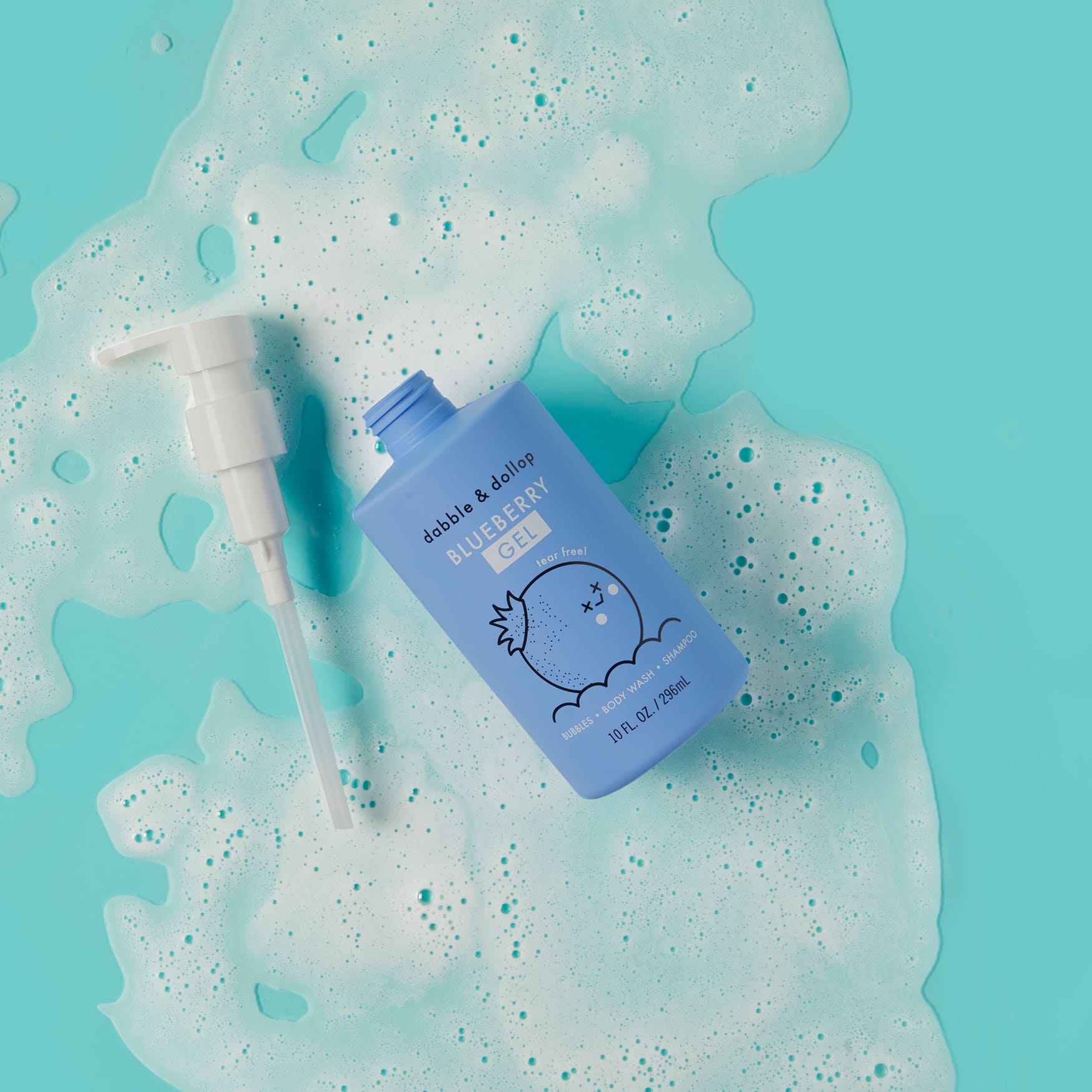 Dabble & Dollop Blueberry Gel bottle sits amidst bubbly foam on a bright teal surface.
