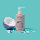 Displaying Dabbie & Dollop coconut gel bubble bath, body wash, and shampoo next to a papercraft coconut.

