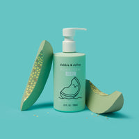 Displays dabble & dollop Honeydew Gel, a tear-free bubbles, body wash, and shampoo, alongside decorative honeydew melon slices.

