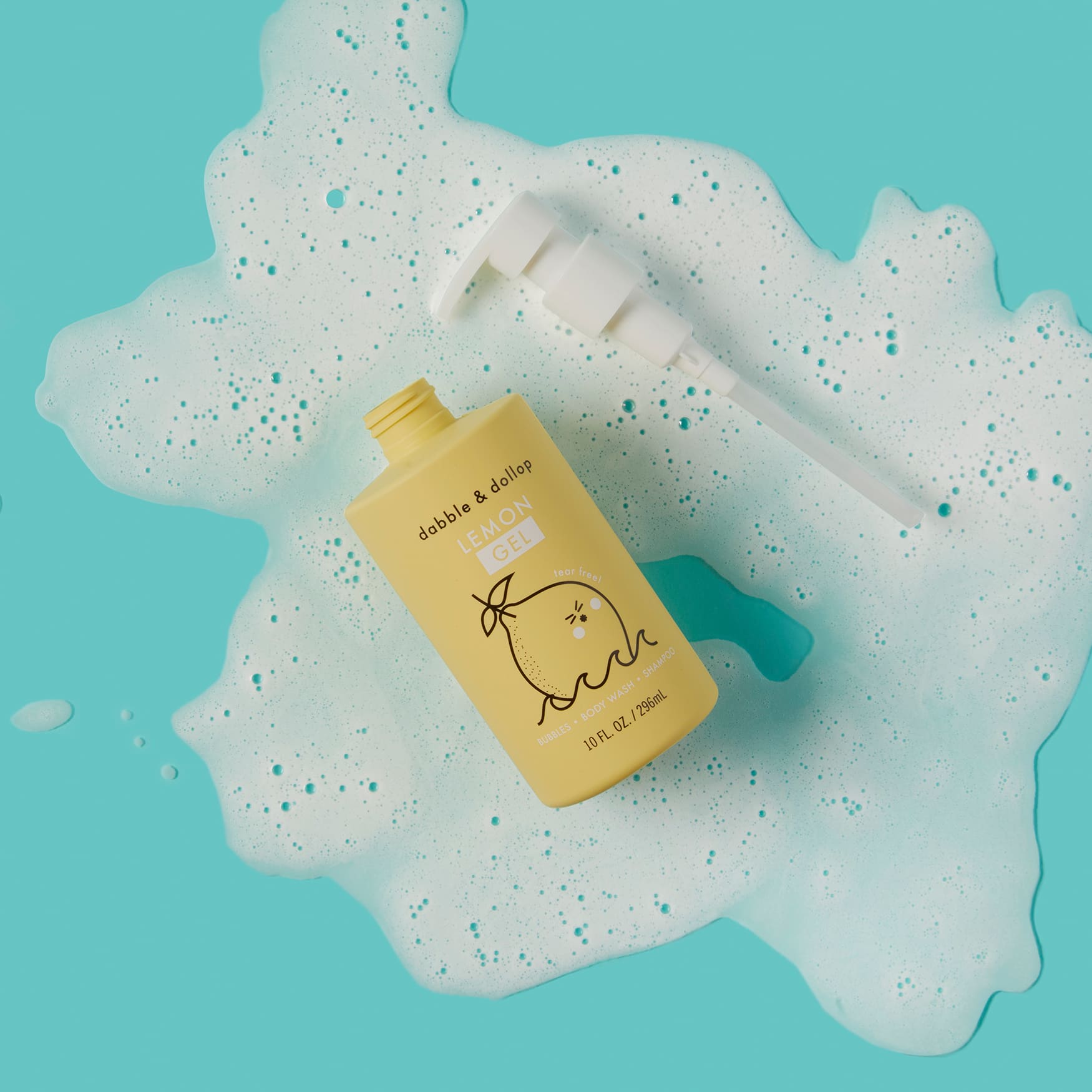 Dabble & Dollop Lemon Gel baby body wash and shampoo bottle sits amidst playful bubbles on a bright blue background.
