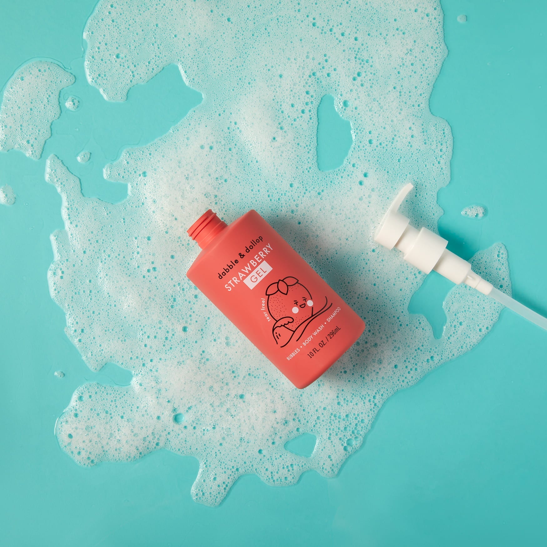 Strawberry gel body wash sits amidst bubbly foam on a bright blue surface.
