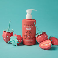 Display a bottle of Dabble & Dollop Strawberry Gel body wash and shampoo, surrounded by playful, handcrafted paper strawberries on a vibrant turquoise background.

