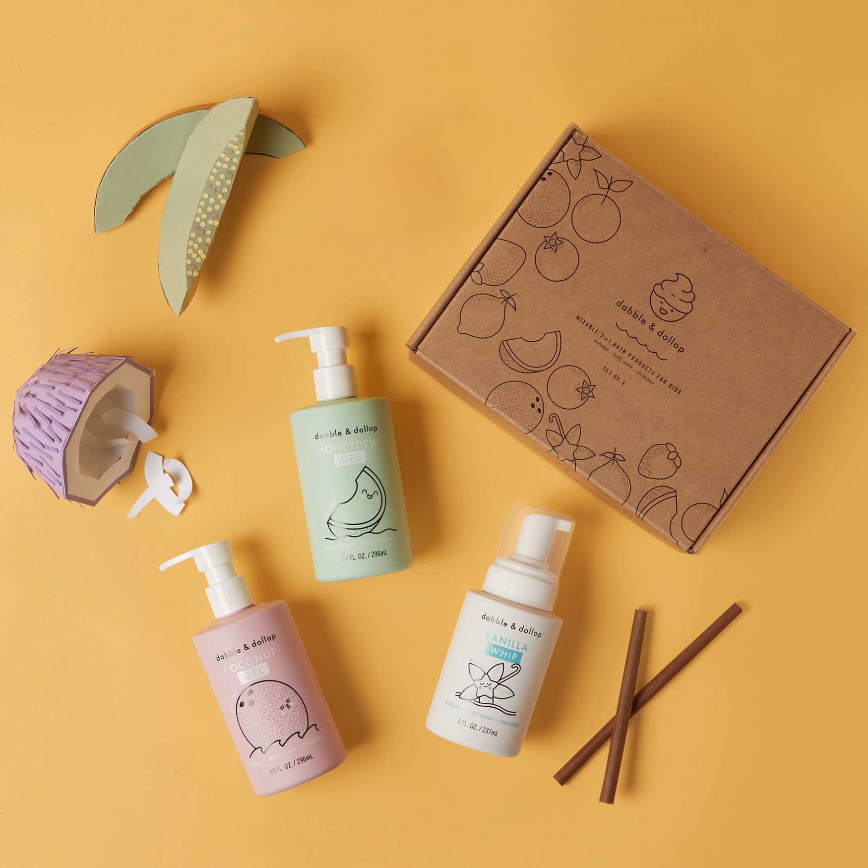 Dabble & Dollop showcases its mixable 3-in-1 bath products for kids, including coconut gel, honeydew gel, and vanilla whip, alongside playful paper-craft coconuts and a gift box.
