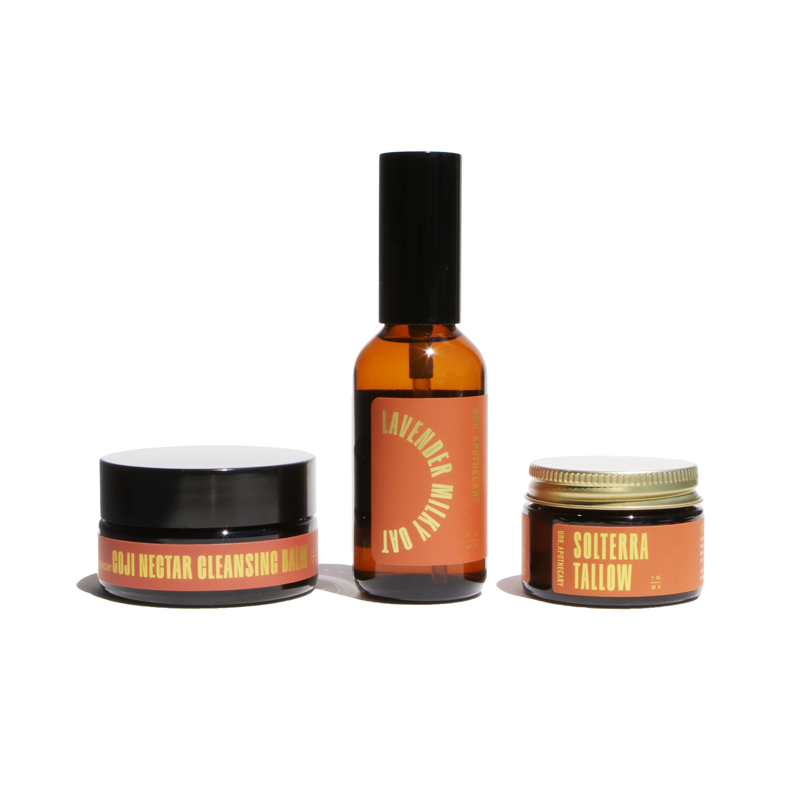 Showcases a skincare set featuring Goji Nectar Cleansing Balm, Lavender Milky Oat serum, and Solterra Tallow moisturizer by URB Apothecary.
