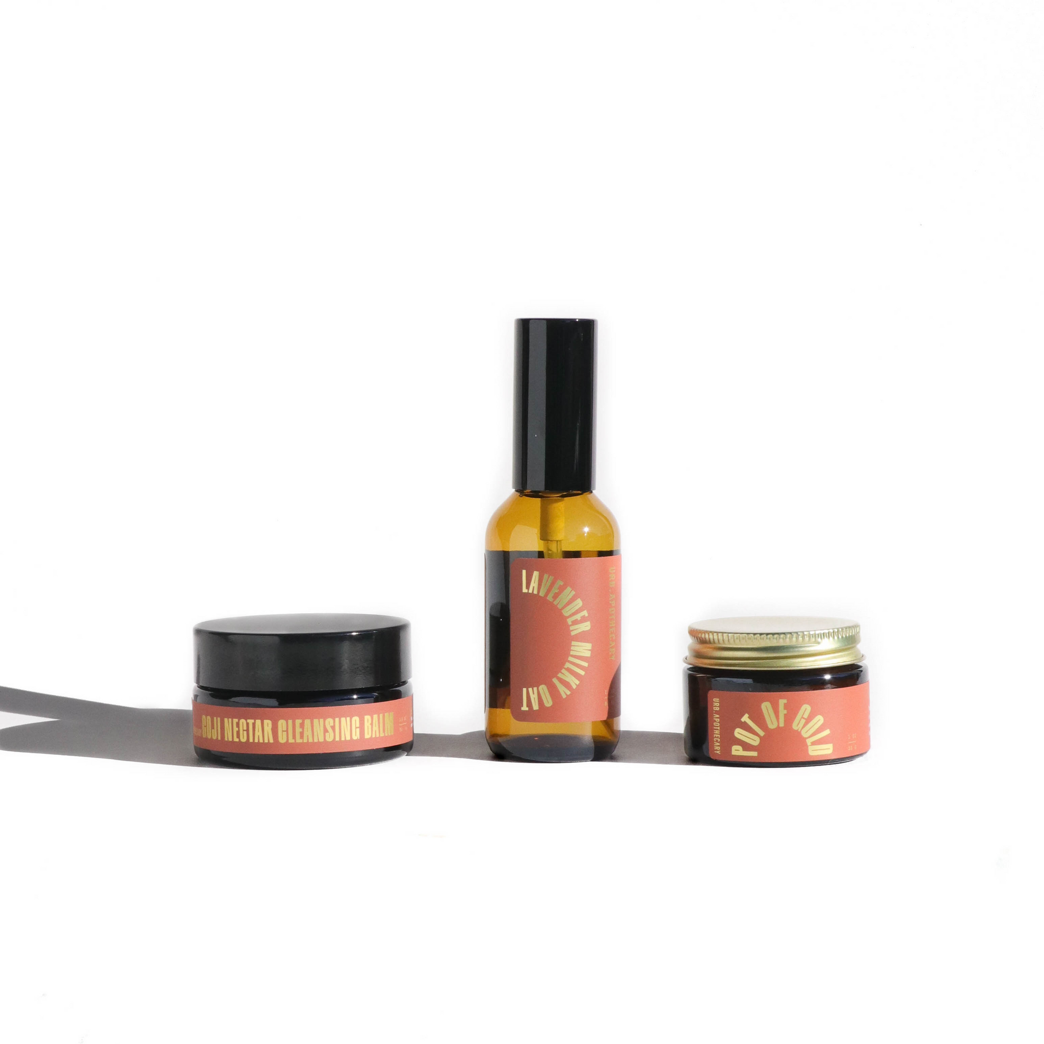 Display presents a trio of Urb Apothecary skincare products: Goji Nectar Cleansing Balm, Lavender Milky Oat, and Pot of Gold.
