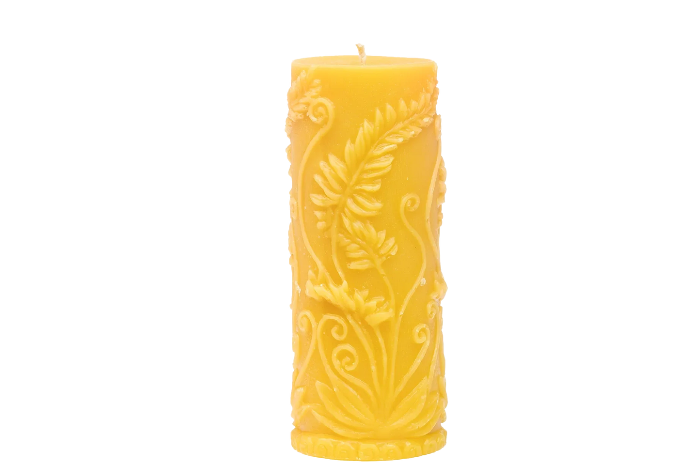 A beeswax candle shows off its intricate, floral-themed carved design.
