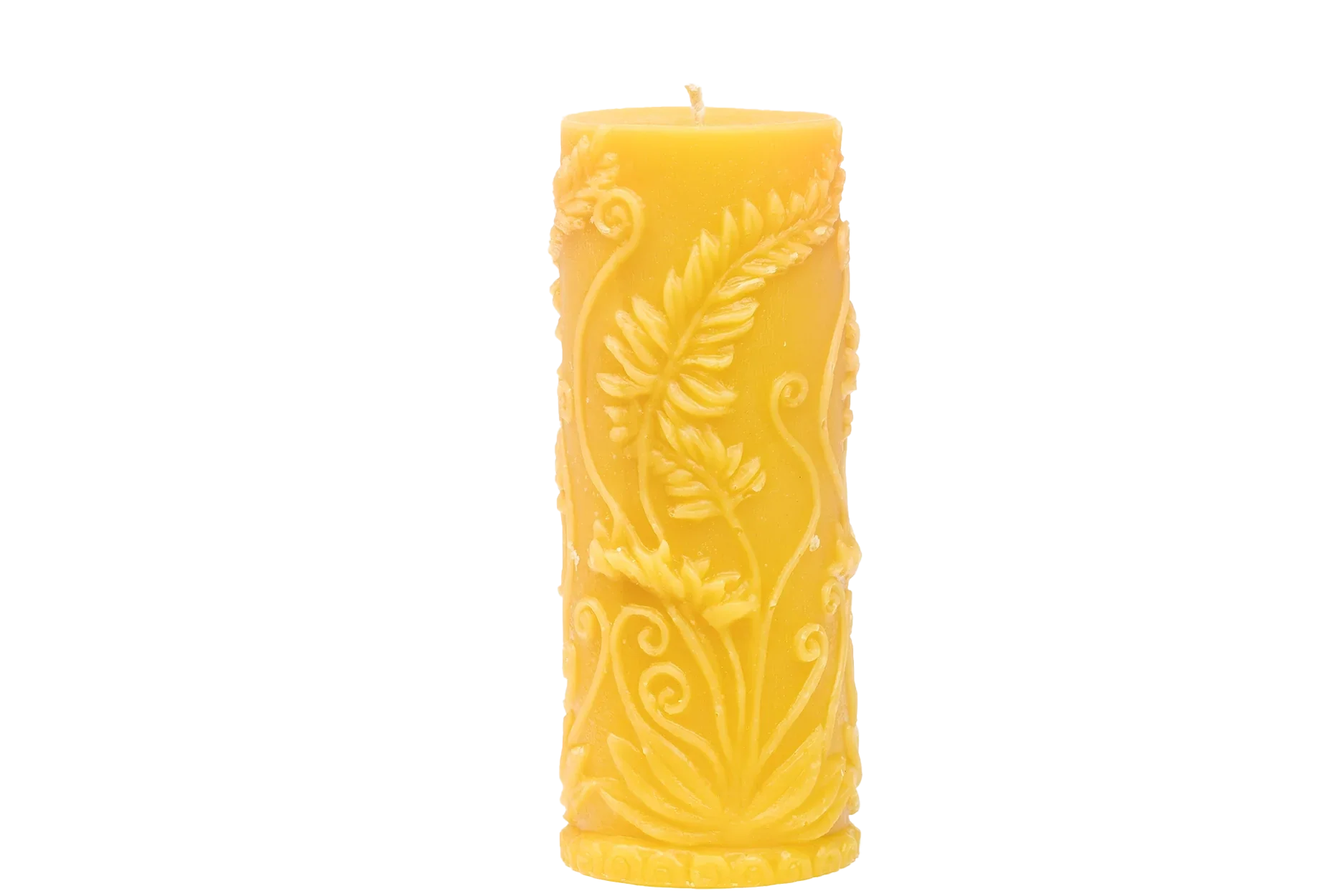 A beeswax candle shows off its intricate, floral-themed carved design.
