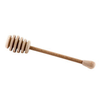 A wooden honey dipper sits against a bright white background.
