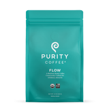 Showcases a teal bag of Purity Coffee Flow, a medium roast whole bean coffee crafted for health and certified organic and bird-friendly.