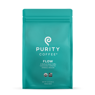 Showcases a teal bag of Purity Coffee Flow, a medium roast whole bean coffee crafted for health and certified organic and bird-friendly.