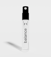 Balance-branded perfume sample sits upright, casting a shadow against a plain background.
