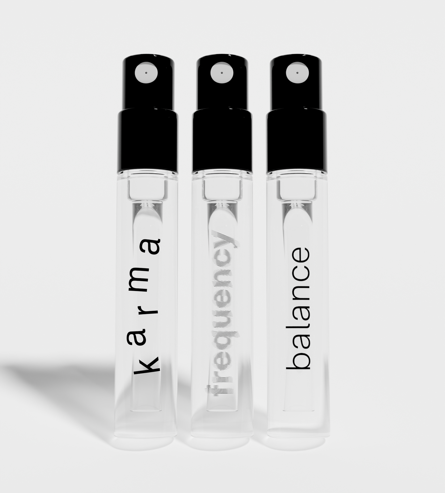 Three sleek travel-size spray bottles display wellness scents labeled Karma, Frequency, and Balance.
