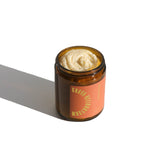 A glass jar holds Guava Heliotrope moisturizing cream from a brand called Uru. Apothocary.
