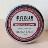 Viewers examine a tin of Rogue Evergreens Incense Cedar beard balm handcrafted from wild-harvested boughs in Ashland, Oregon, boasting 100% natural, paraben-free ingredients.
