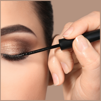 Applying black eyeliner to the upper eyelid as part of a beauty makeup routine.
