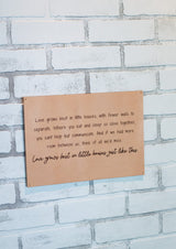 Wall decor displays an inspirational quote about love and small homes against a white brick background.
