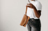 Woman models a stylish tan leather crossbody phone wallet bag from Urban Southern.
