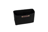 Displaying a black felt purse organizer with interior pockets and a leather logo patch against a white background.
