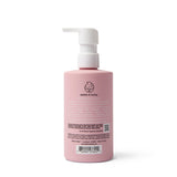 A pink bottle of Dabble & Dollop 3-in-1 shampoo, bubble bath, and body wash sits upright with its pump dispenser visible.

