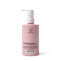 A pink bottle of Dabble & Dollop 3-in-1 shampoo, bubble bath, and body wash sits upright with its pump dispenser visible.
