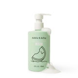 Dabble & Dollop Honeydew Gel bubbles body wash and shampoo bottle sits amidst foamy suds.
