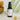 Annmarie Anti-Aging Serum bottle sits among decorative plants.
