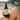 A person displays a bottle of Annmarie Coconut Body Oil, highlighting its enhanced herb formula for natural skincare.

