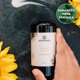 Hand holds Annmarie Radiant Skin Silk luxurious body lotion, featuring an enhanced herb formula, amidst bright yellow sunflowers.
