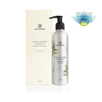 Annmarie's Sweet Sunrise Shampoo, a herb-infused hair wash for all hair types, sits next to its packaging, displaying the Healing Lifestyles Earth Day Beauty Awards Winner 2020 badge.
