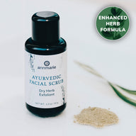 Annmarie Ayurvedic Facial Scrub, a dry herb exfoliant with an enhanced formula, sits beside a small pile of the product.
