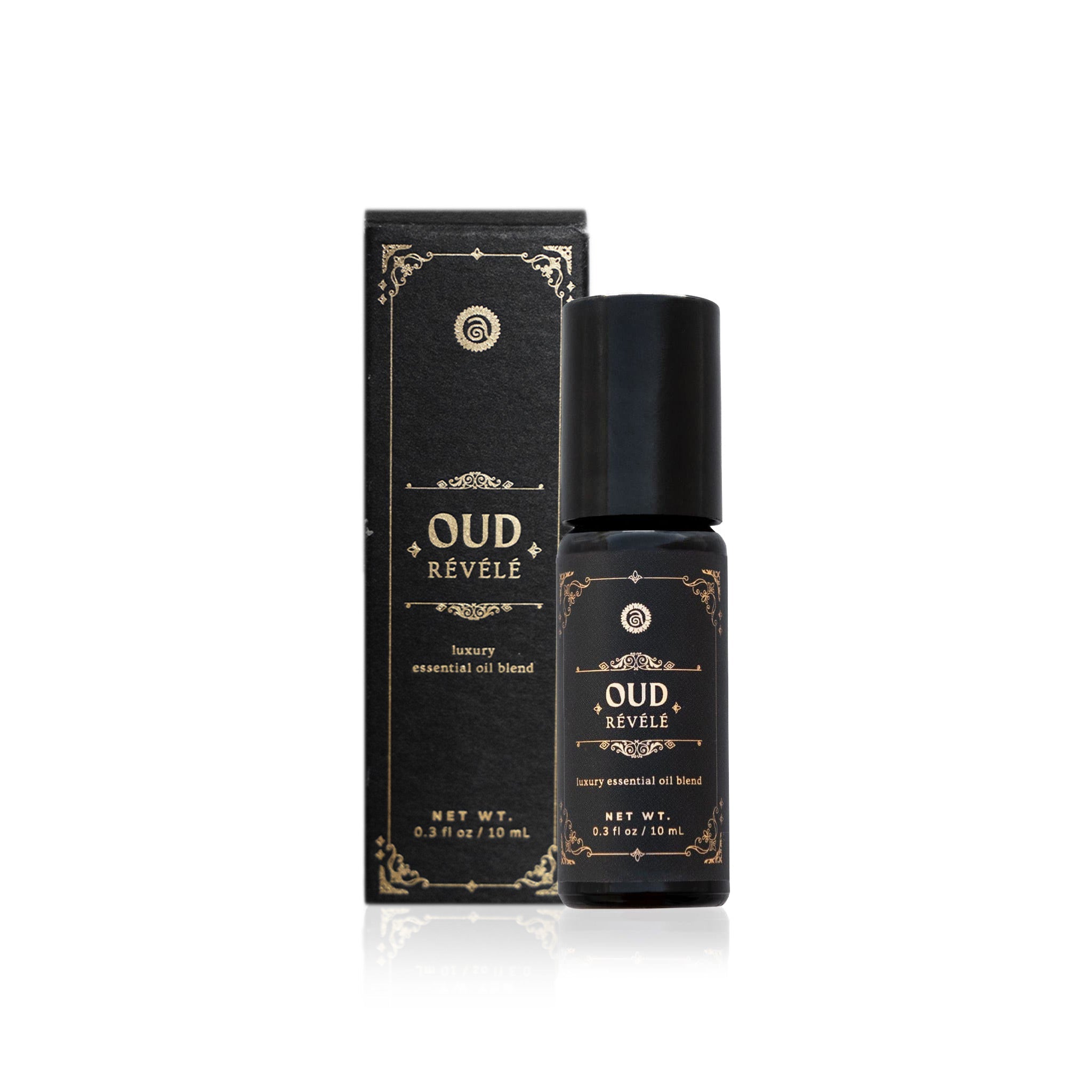 Oud Révélé luxury essential oil blend and box sit elegantly on a white surface.
