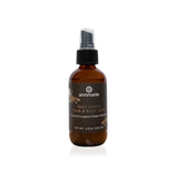 Annmarie's Palo Santo hair and body mist sits on a white surface, showcasing its crystal-energized water perfume.
