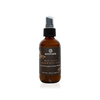 Annmarie's Palo Santo hair and body mist sits on a white surface, showcasing its crystal-energized water perfume.
