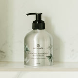 Annmarie Rosemary Peppermint Body Wash sits on a marble shelf, showcasing its invigorating gel cleanser.
