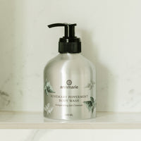Annmarie Rosemary Peppermint Body Wash sits on a marble shelf, showcasing its invigorating gel cleanser.
