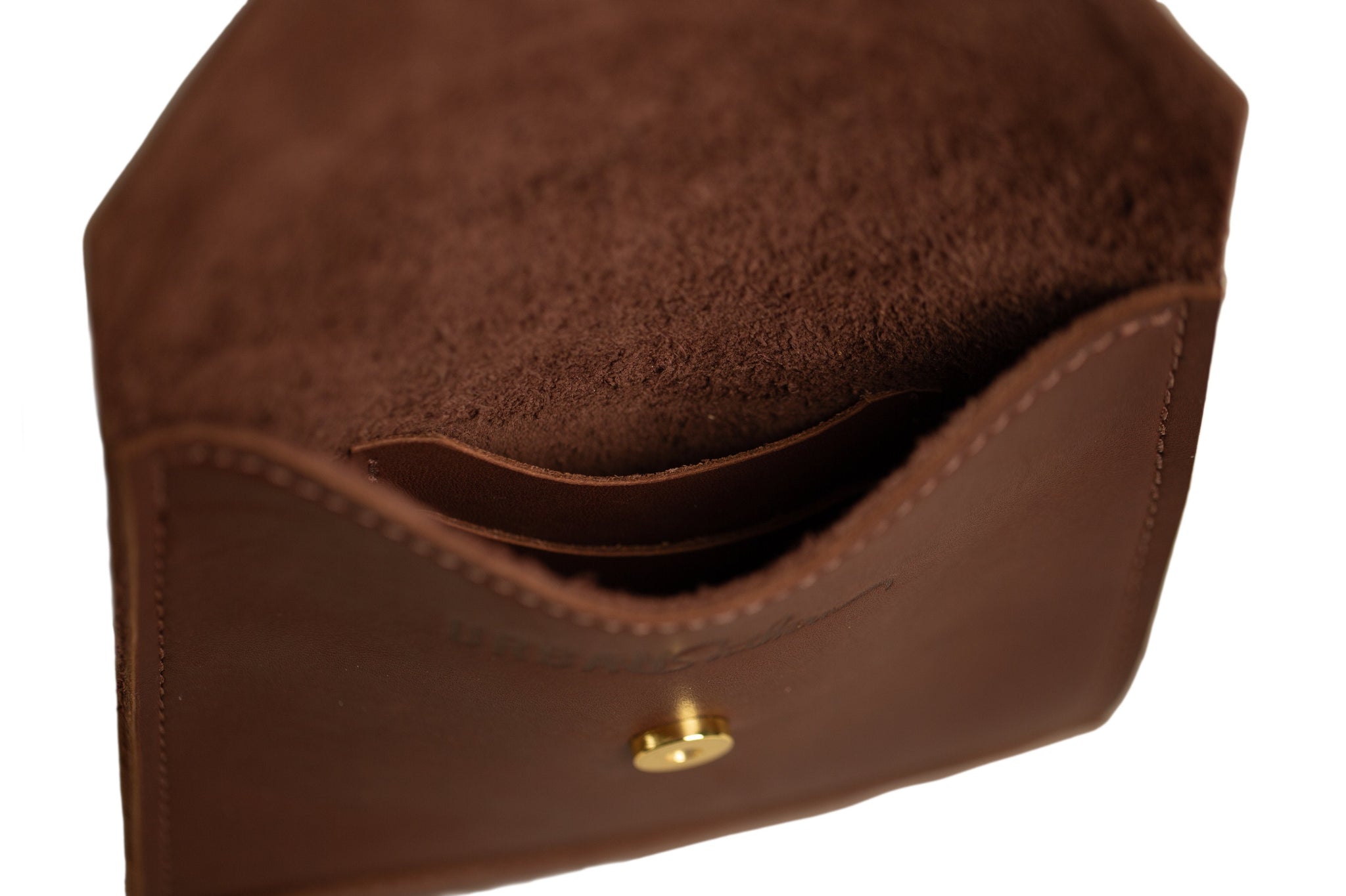 Close-up showcases the luxurious interior of an open brown leather card holder wallet with a gold snap closure.
