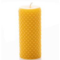 A natural beeswax candle displays its unique honeycomb texture.
