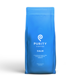 Purity Coffee displays their Calm blend of decaffeinated organic whole bean coffee in a blue bag.

