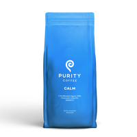 Purity Coffee displays their Calm blend of decaffeinated organic whole bean coffee in a blue bag.
