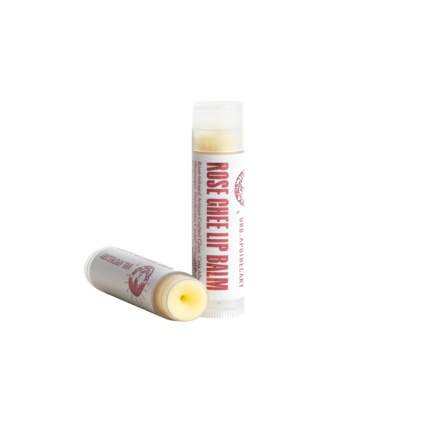 Two tubes of URB Apothecary Rose Ghee Lip Balm sit on a white surface, highlighting its rose-infused and artisan-crafted ingredients.
