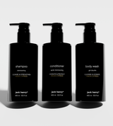 Three black pump bottles showcase Jack Henry shampoo, conditioner, and body wash with Hinoki Cypress scent.
