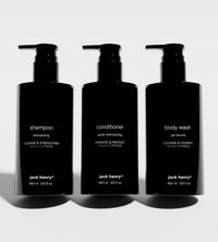 Three black pump bottles showcase Jack Henry shampoo, conditioner, and body wash with Hinoki Cypress scent.
