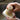 Hands scrub a white dish soap bar with a bamboo dish brush over a sink.

