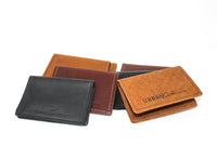 Display showcases an assortment of handcrafted leather wallets in varying colors and textures by Urban Southern.
