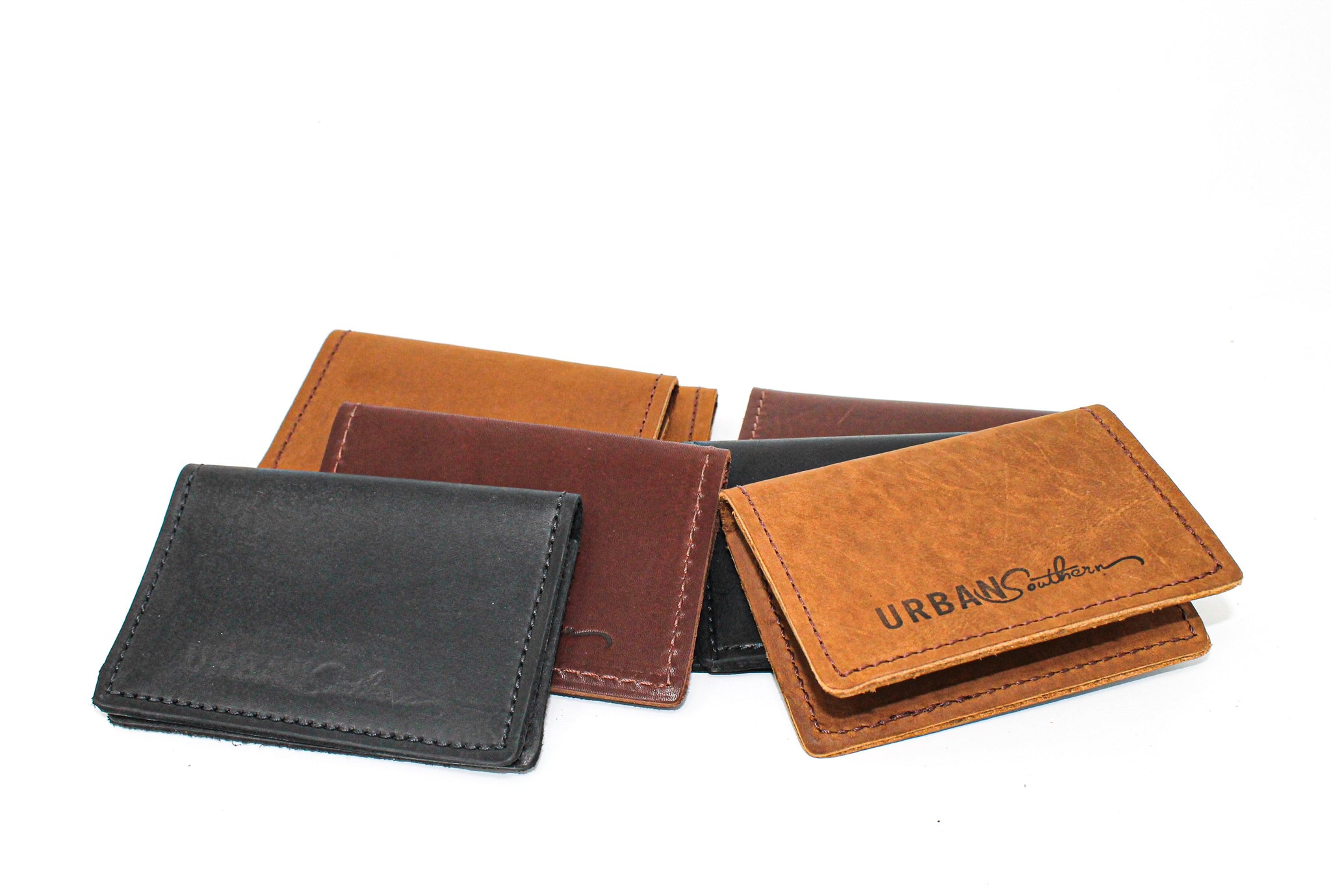 Display showcases an assortment of handcrafted leather wallets in varying colors and textures by Urban Southern.
