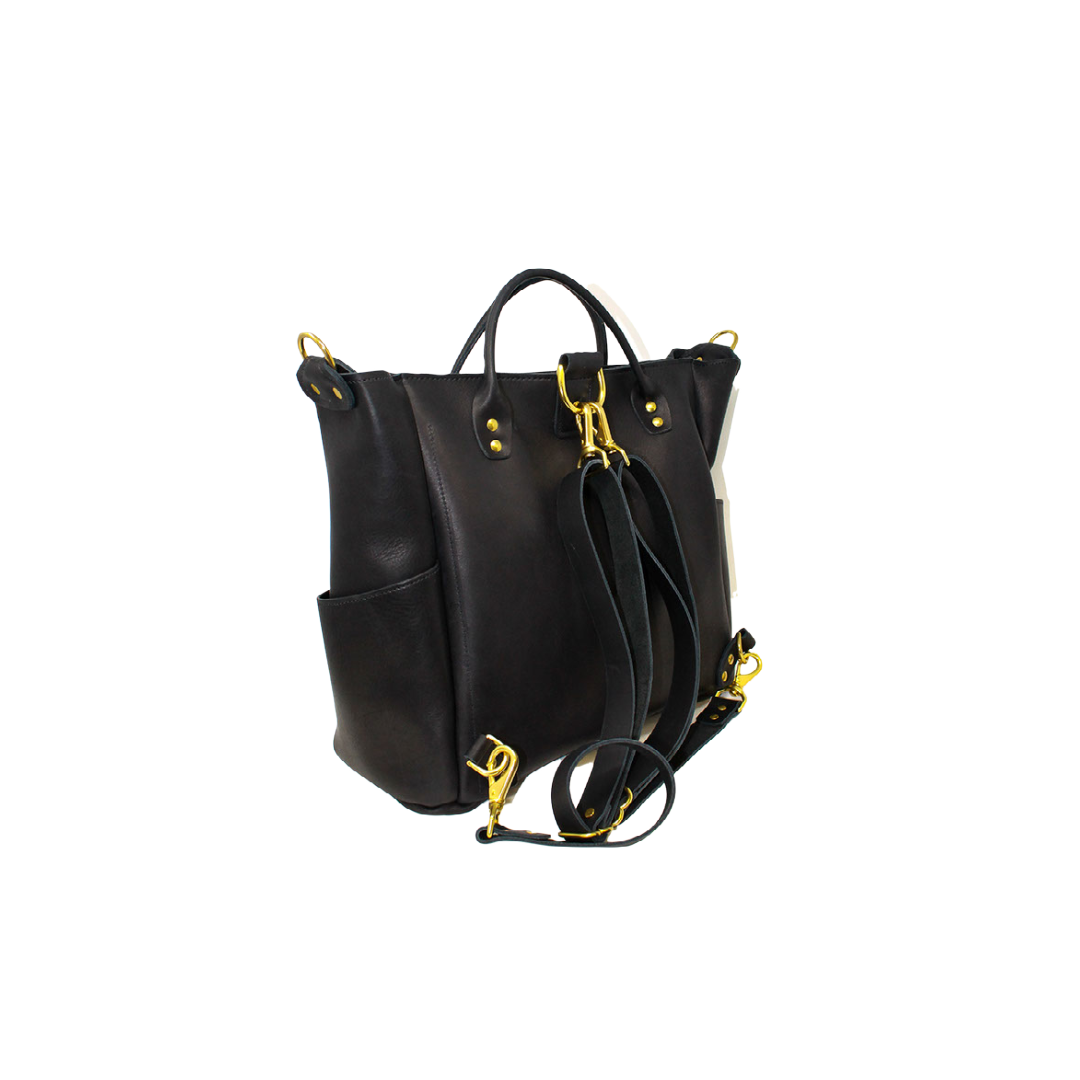 A black leather convertible tote bag shows off its adjustable shoulder straps and gold hardware.
