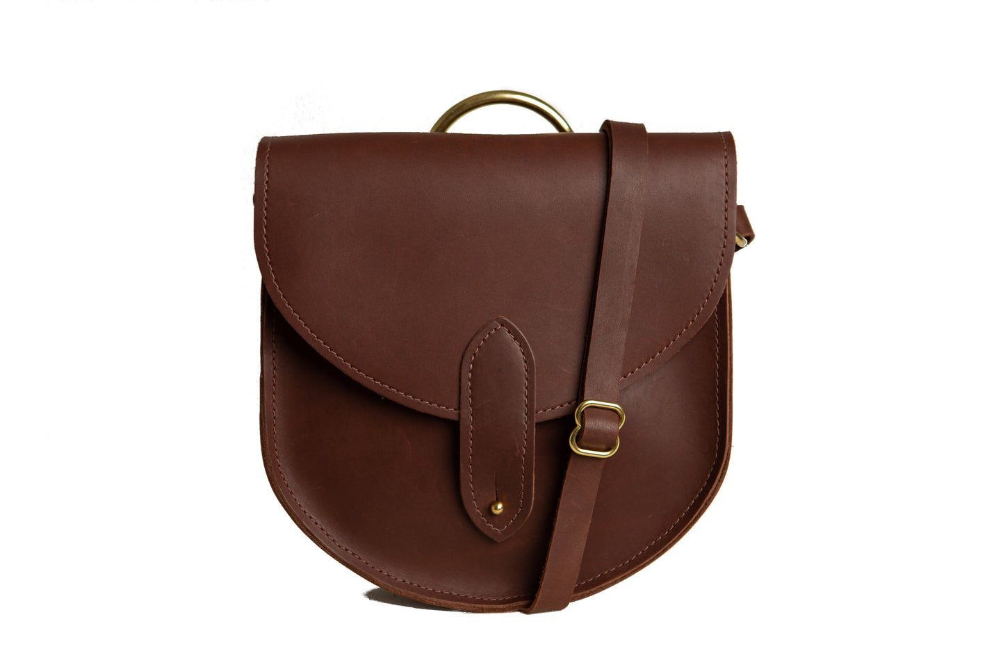 A stylish brown leather saddle bag with gold hardware sits against a white backdrop.
