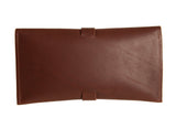 A brown leather envelope-style wallet features a simple strap closure.
